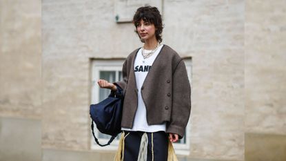 Fashion week guest looking away from the camera with short dark hair and a pink chanel dress