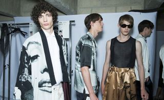 Three male models wearing clothing by Dries Van Noten in black, white and gold.