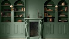 Built-in bookcase alcoves and a period fireplace painted in Webster Green by Benjamin Moore.