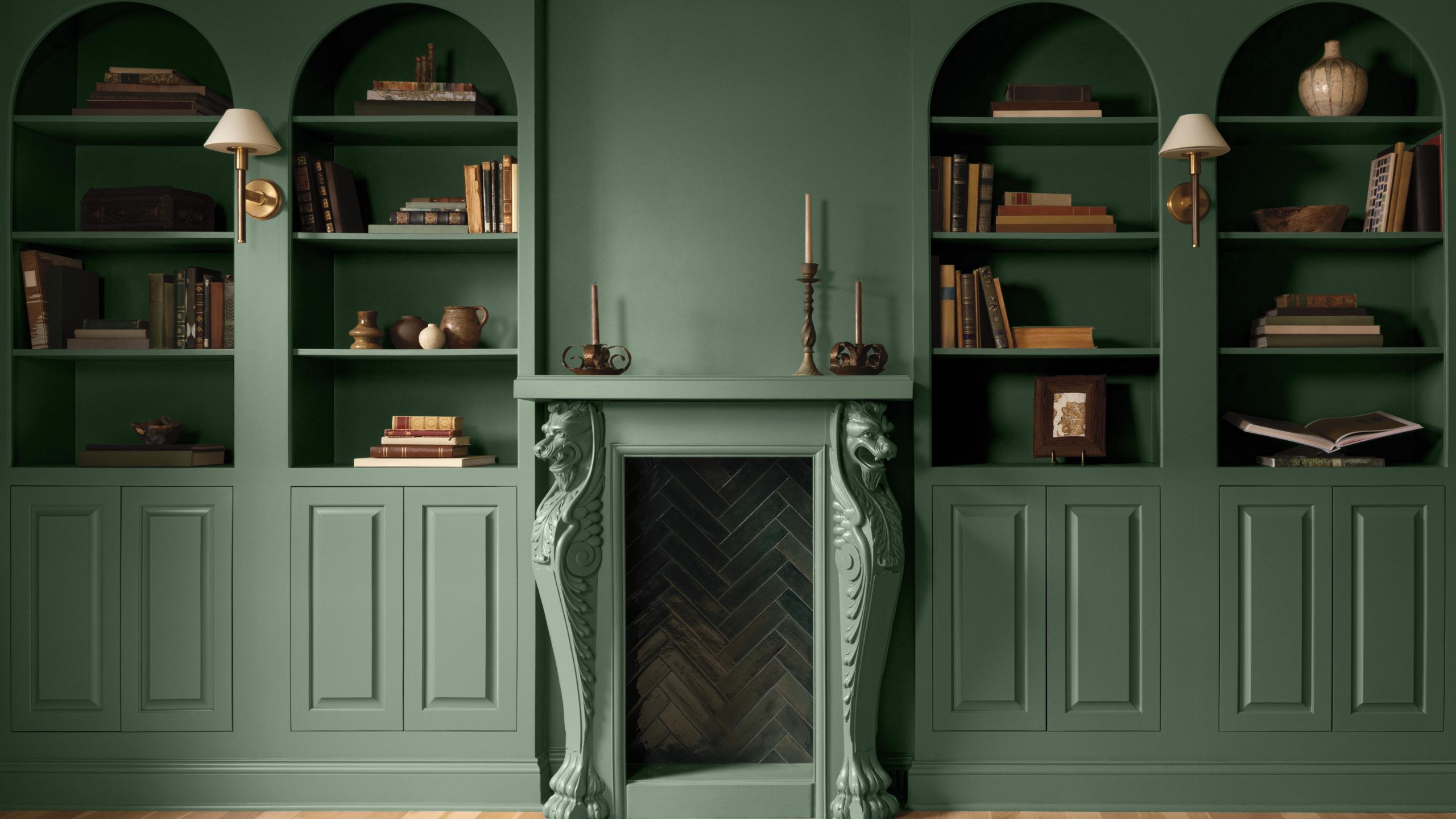 Built-in bookcase alcoves and a period fireplace painted in Webster Green by Benjamin Moore.