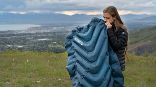 Woman inflating Klymit Static V Luxe SL sleeping pad