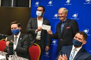 NASA Administrator BIll Nelson presents Lunar Outpost CEO Justin Cyrus with a check for 10 cents.