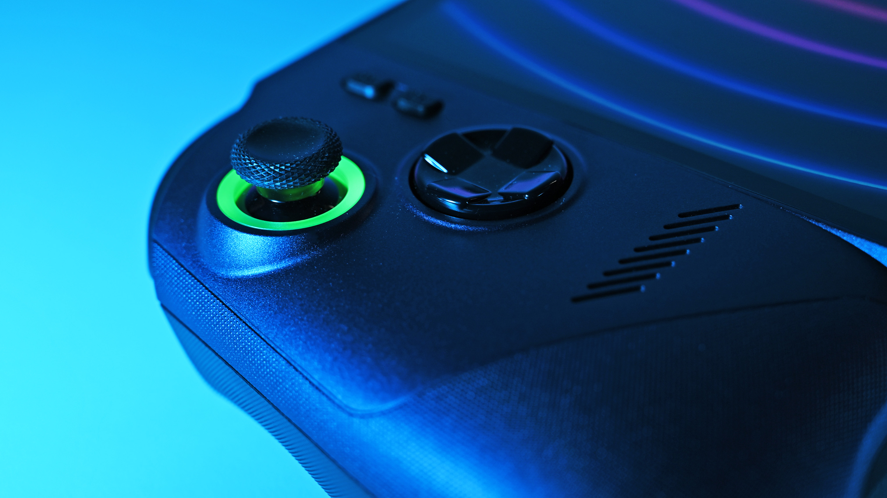 Close-up of the device's left thumbstick and D-pad, highlighting a textured thumb grip and a vibrant green LED ring beneath the stick.