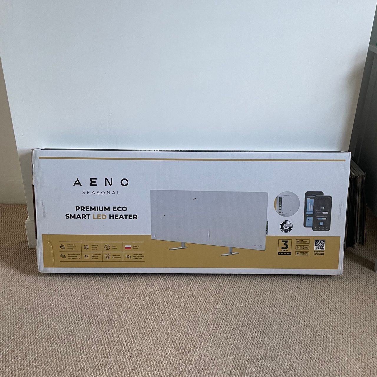Aeno Premium Eco Smart Heater box on cream carpet with white walls behind it
