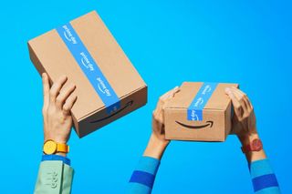 Two Amazon parcels decorated with Amazon Prime Day tape help aloft by happy customers