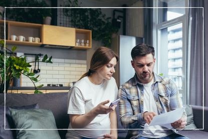 expectant parents sitting on sofa looking at paperwork