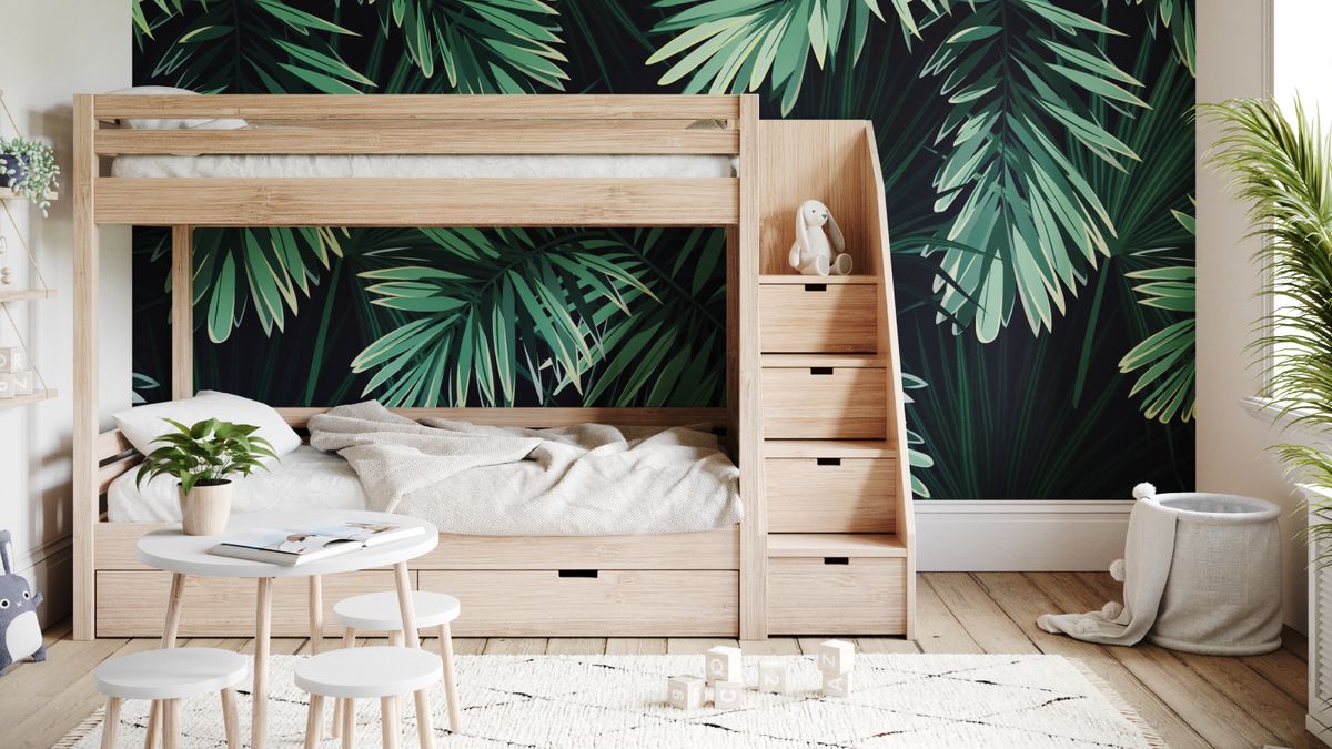 wooden bunkbeds with steps including drawers and bold green leafy wallpaper mural on wall