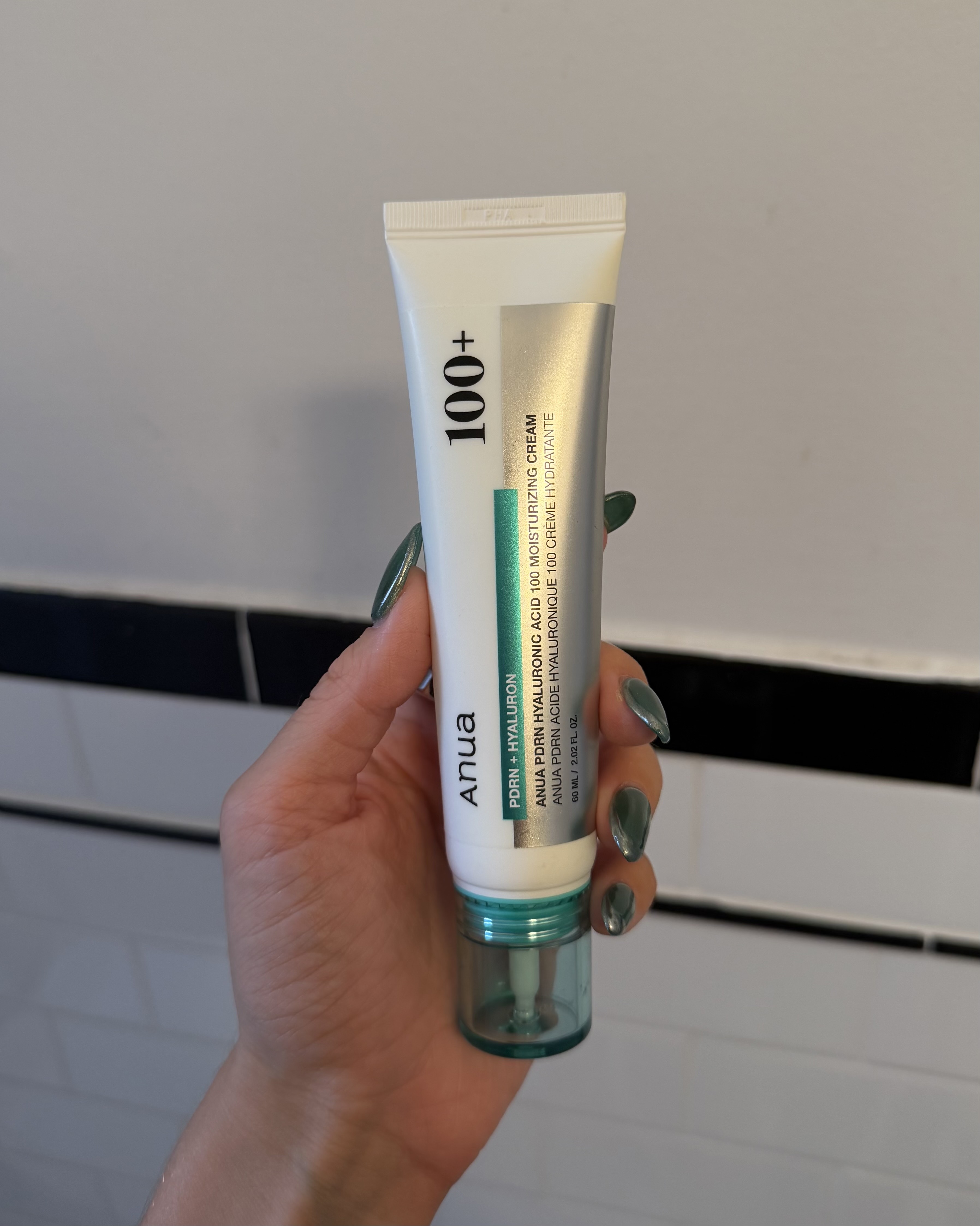 An image of Who What Wear associate beauty editor Alyssa Brascia holding the Anua PDRN Hyaluronic Acid 100 Moisturizing Cream.