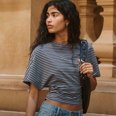Woman wearing striped blue Cotton on top and denim jeans