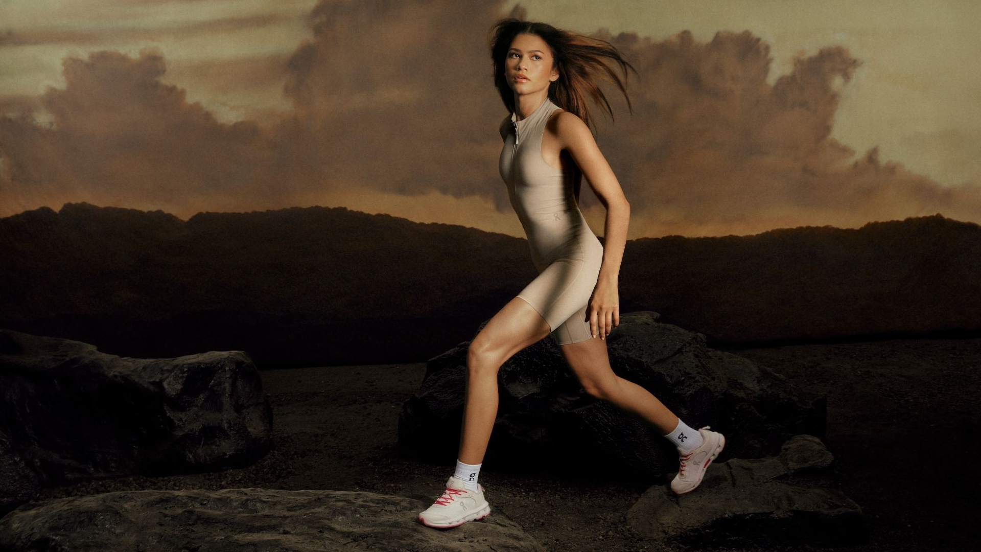 Zendaya poses on a set at sunset wearing a bodysuit with the On sneakers she designed
