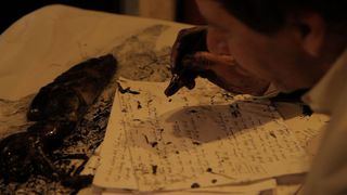 Man writing a letter with ink