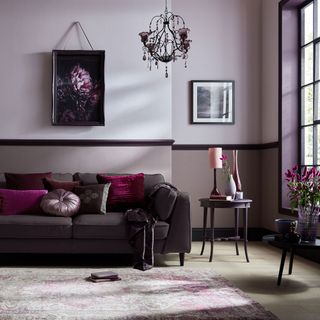 A purple sofa in a purple living room with a chandelier