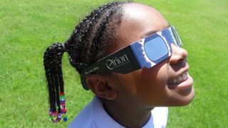 girl wearing solar eclipse glasses