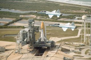 Two NASA T-38 jets fly over space shuttle Endeavour in 2009.
