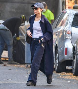 A photo of Zoe Kravitz wearing a navy blue longline barn coat and wide-leg jeans for a post-breakup stroll in New York City.