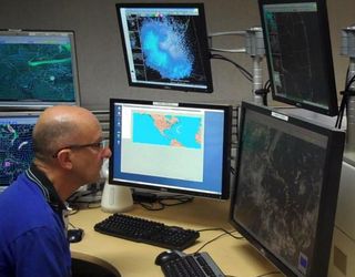 A forecaster keeps his head on a swivel, monitoring a developing storm.