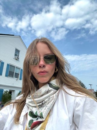 Nikki Chwatt wears Vogue Eyewear glasses with a white shirt and silk scarf.