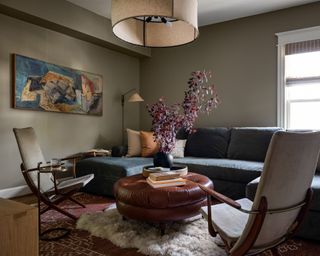 living room with olive green walls and neutral decor