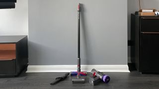 The Dyson Micro 1.5kg and its attachements leaning against a wall