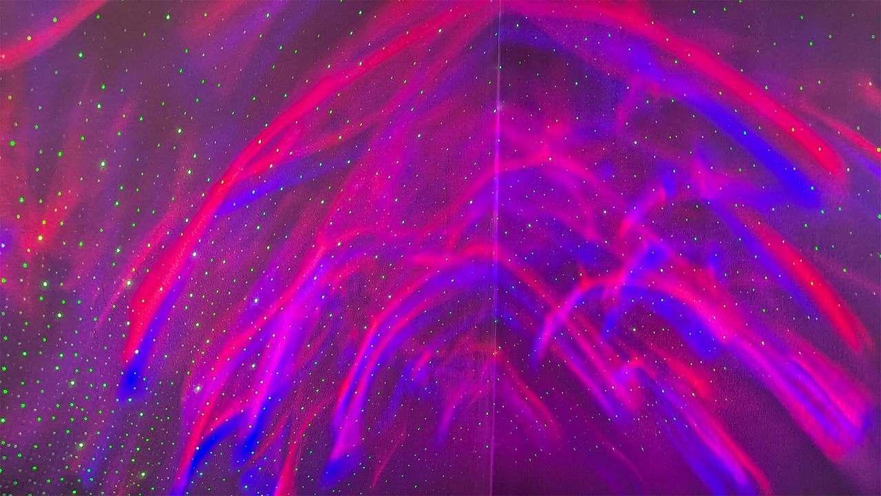 YgiTK Northern Galaxy Lights Projector during Review, on a wooden table against a dark coloured wall