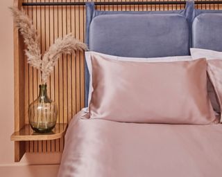 silk bed sheets on a bed with wood slat headboard and bedside table with pampas grass in a vase - Peep silk