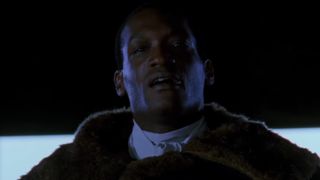 Candyman stands wearing a fur coat in Candyman