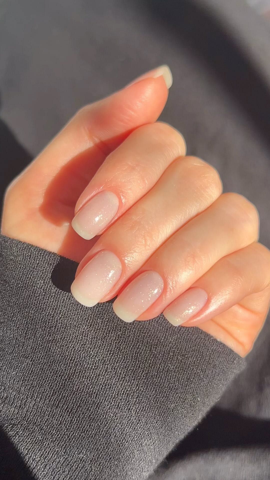 Squoval shaped nails with a sheer, subtly sparkly nail polish