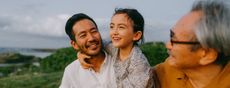 Multigenerational Asian family, grandfather, son, and grandchild overlooking the mountains