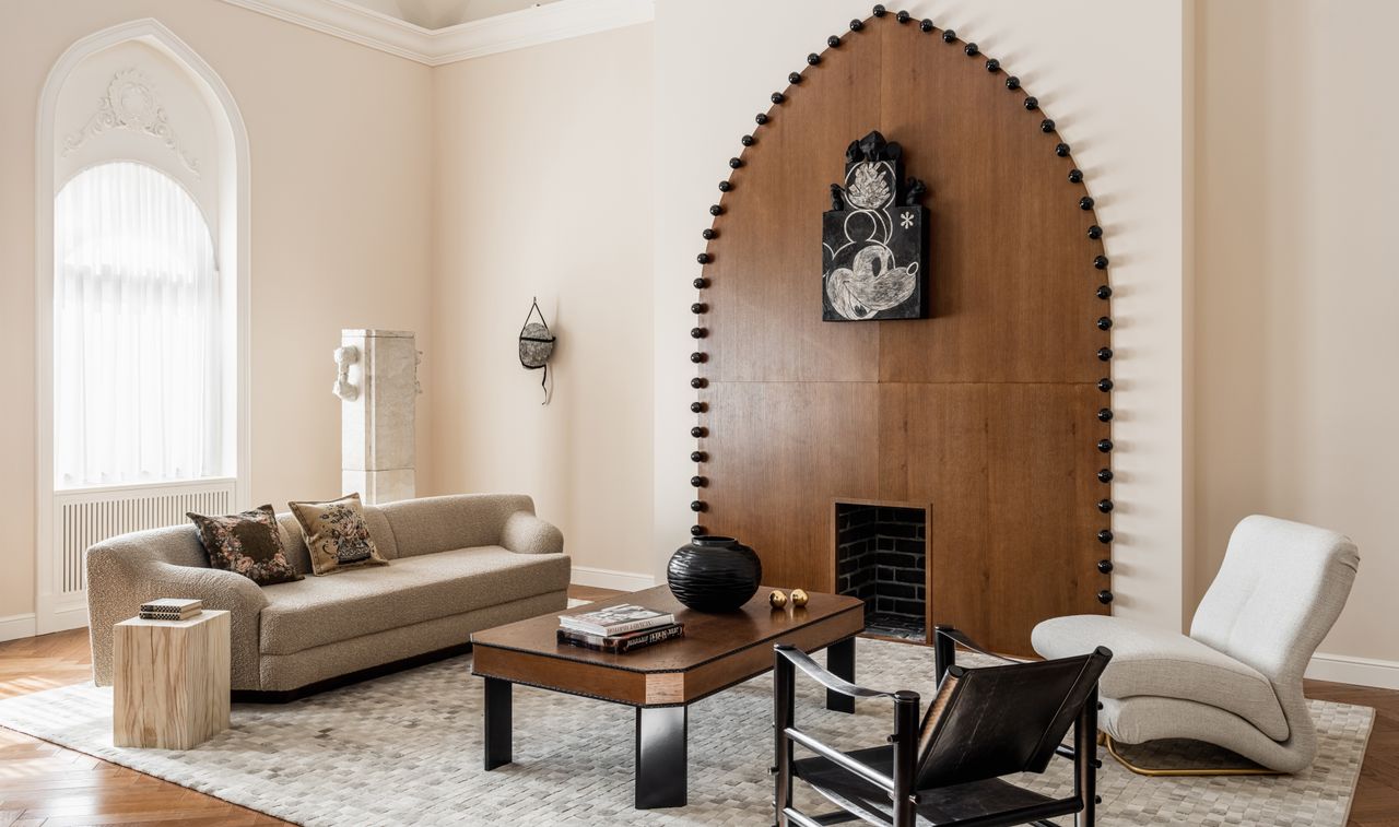 A living room with a beige and white furniture, and cream rug