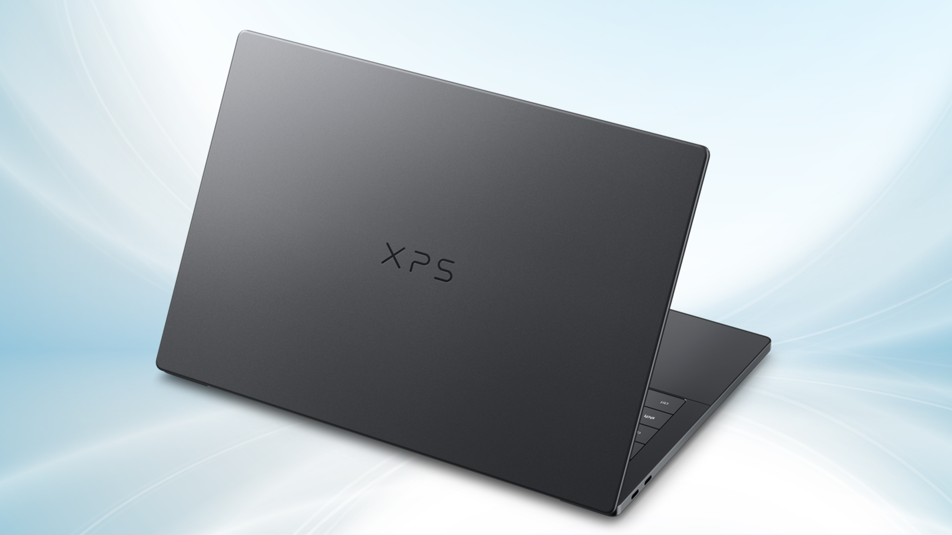 A sleek black laptop with the word "XPS" on the back cover, slightly open. It rests on a smooth gradient background, conveying a modern, minimalist feel.