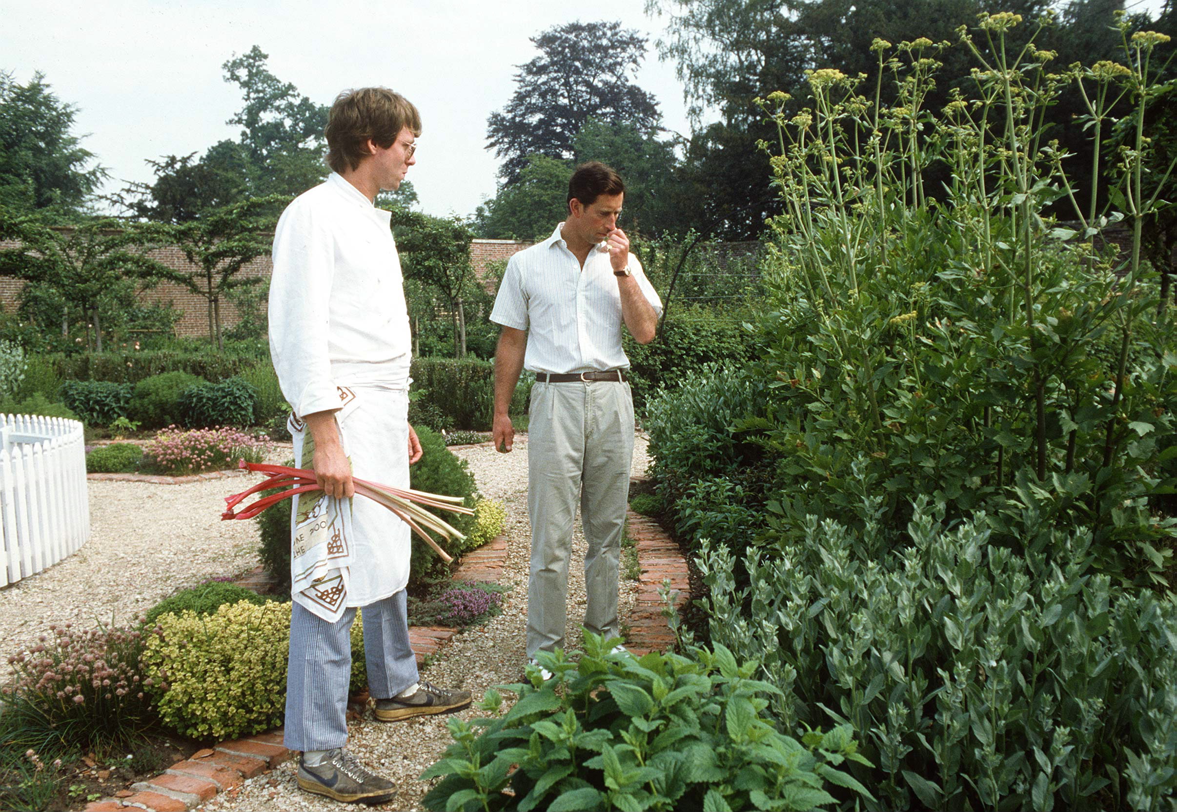 King Charles sniffing herbs in the garden at Highgrove with his chef standing nearby