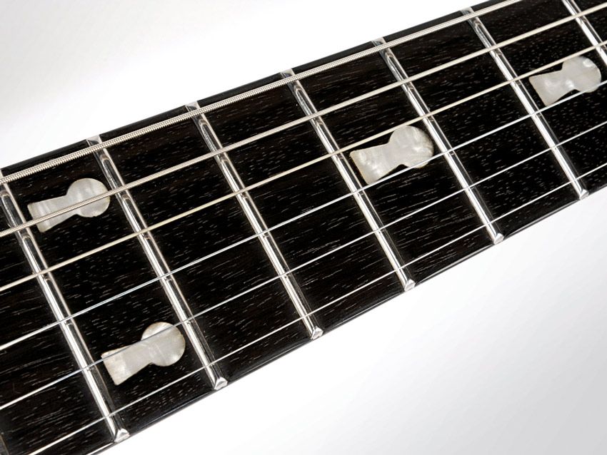 The ebony fretboard comes with neat keyhole markers