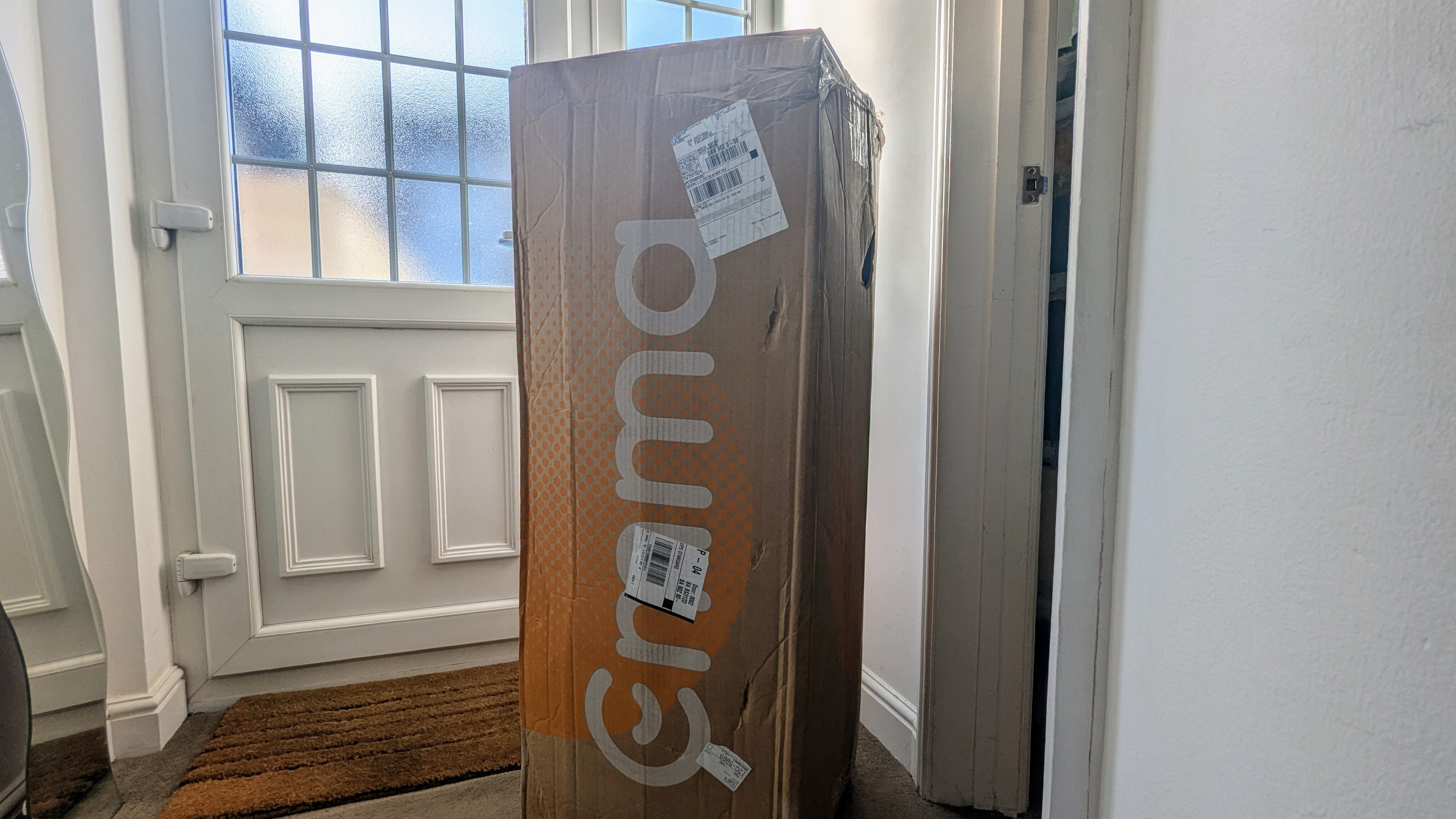 A boxed Emma Hybrid Airgrid mattress kept near the front door