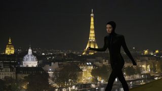 Alicia Vikander walking on a roof at night in Paris in Irma Vep