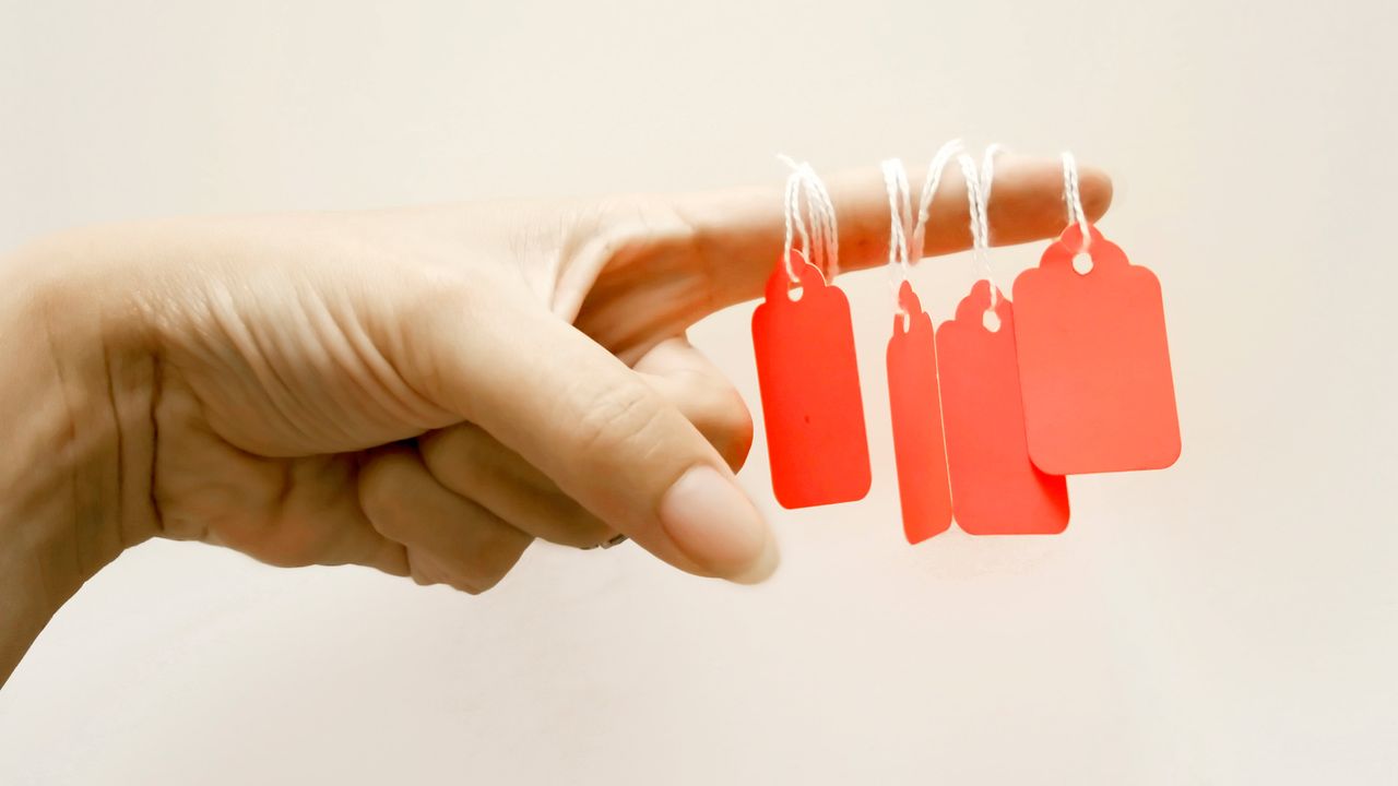 Price tags dangling from a woman&amp;#039;s finger