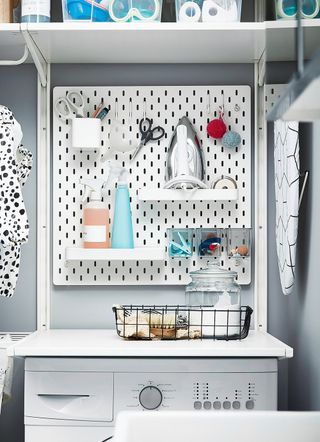 White SKÅDIS pegboard in a laundry room