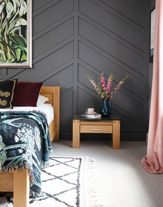 Paneled chevron effect black wall in a bedroom
