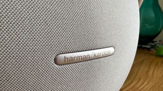 Harman Kardon Studio Onyx 8 on a wooden sidetable Harman Kardon Logo