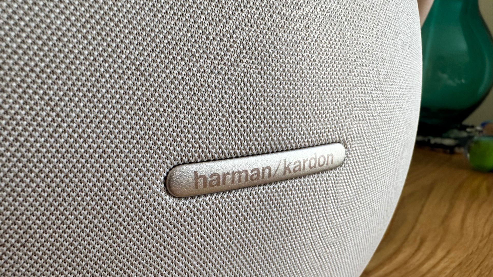 Harman Kardon Studio Onyx 8 on a wooden sidetable Harman Kardon Logo
