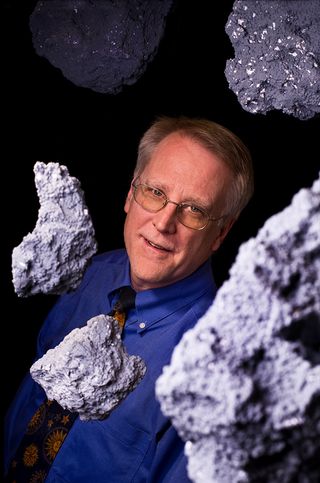 Professor Richard Binzel, an MIT astronomer who has studied asteroids for 50 years, surrounded by space rocks