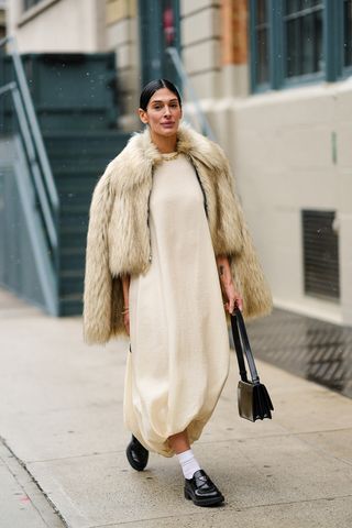 Woman wearing a faux fur jacket outfit.