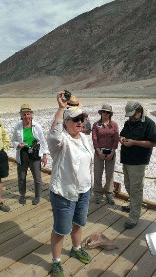 Susanne Douglas holds up a sample of microbial life that thrives in the harsh environments of Badwater Basin in Death Valley National Park.