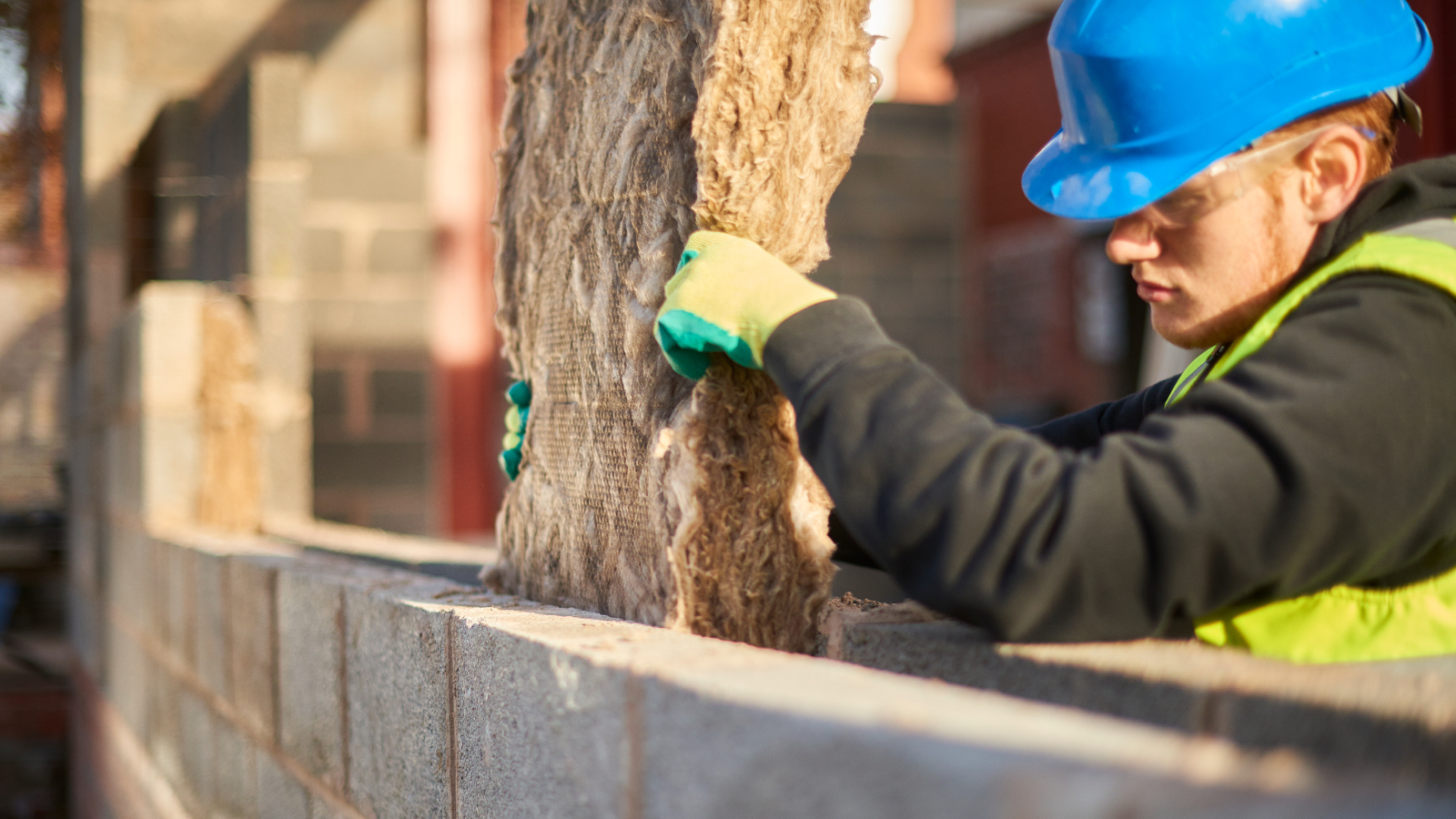 Builder putting insulation in cavity wall