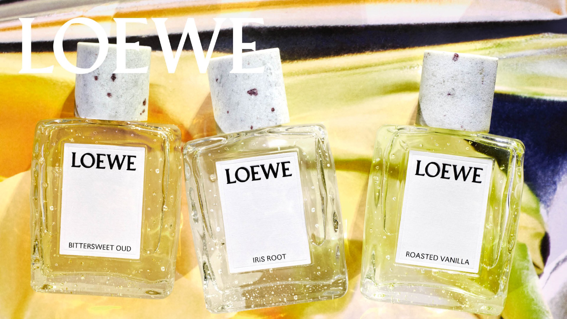 loewe ibttersweet oud iris root and roasted vanilla bottlesfragrance bottles on a yellow background