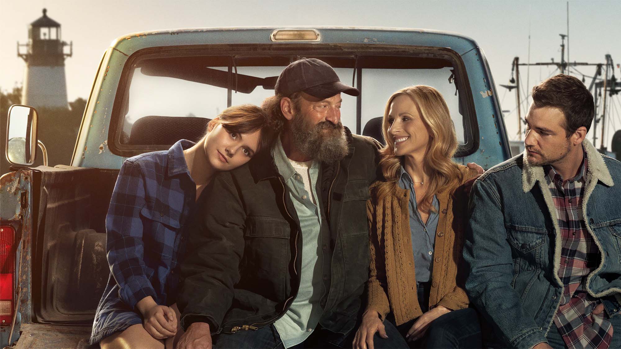 Emilia Jones, Troy Kotsur, Marlee Matlin, and Daniel Durant sitting in the back of a pickup truck for the Apple TV Plus film CODA