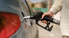 Woman using gas pump to add fuel to her car