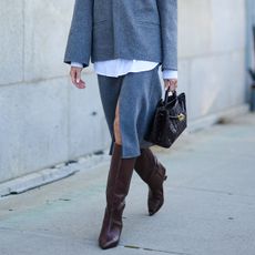 Woman in brown boots and gray skirt