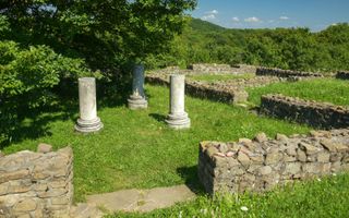 Old Roman columns on a grassy field in Dacia, Romania