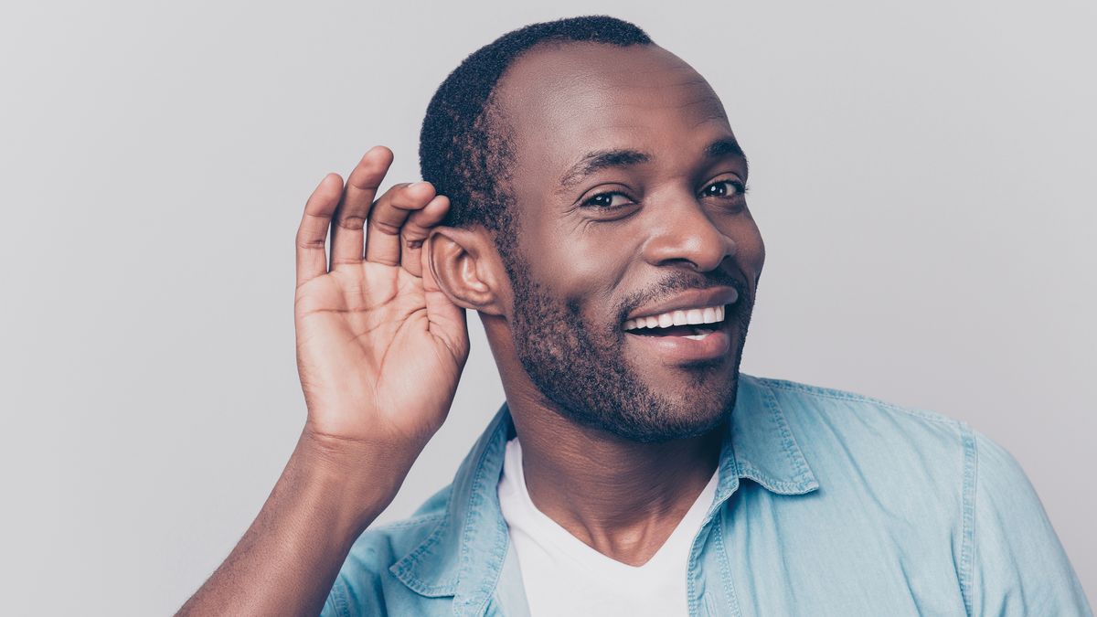 A man cupping his hand up to his ear