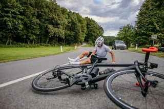 The best bicycle insurance will cover your medical bills as well as paying out for a damaged bike. This image shows a bike on the ground on it's side and a rider in the background looking like they feel off the bike.